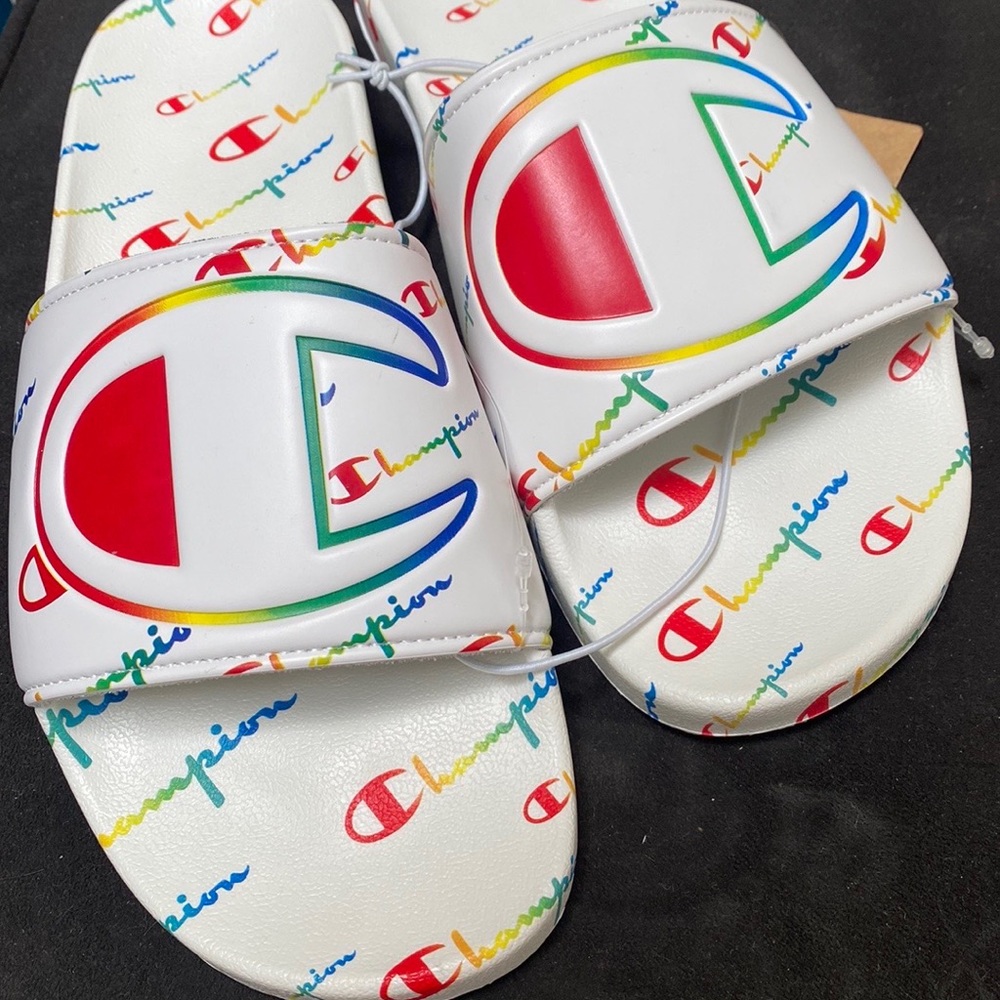 Champion white sandals with rainbow words all around.